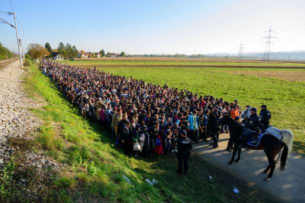 -- AFP PICTURES OF THE YEAR 2015 -- Police escort migrants and asylum seekers as they walk to a refugee centre after crossing the Croatian-Slovenian border near Rigonce on October 24, 2015. Bulgaria, Romania and Serbia threatened to close their borders if EU countries stopped accepting migrants, as European leaders prepared for a mini summit on the continent's worst refugee crisis since World War II. AFP PHOTO / JURE MAKOVEC