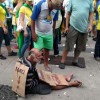 Manifestantes da Paulista vestem morador de rua com placa “tomei no c*” mendigo-paulista