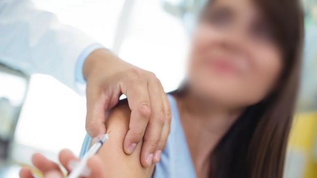mulher tomar vacina