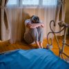 Unhappy lonely depressive woman is sitting alone in a room